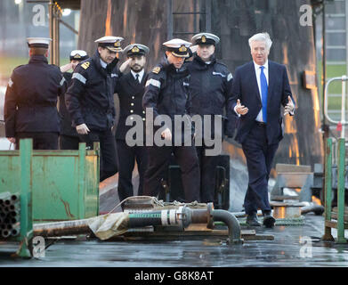 Verteidigungsminister Michael Fallon (rechts) mit Daniel Martyn (Front Center), dem Kommandanten der HMS Vigilant und dem Konteradmiral der U-Boote und dem stellvertretenden Leiter des Marinestabs John Weale (vorne links) bei einem Besuch des Vanguard-Klasse-U-Bootes HMS Vigilant, einem der vier nuklearen Kriegsheadträger-U-Boote des Vereinigten Königreichs, Am HM Naval Base Clyde, auch bekannt als Faslane, in Schottland. Stockfoto