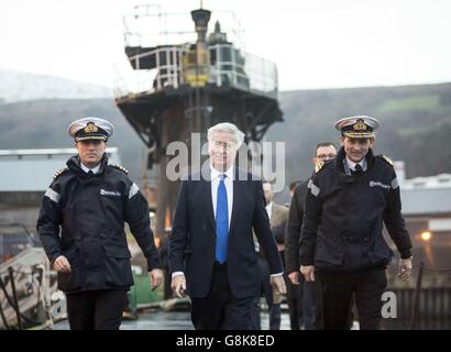 Verteidigungsminister Michael Fallon (Mitte) mit Daniel Martyn (links) Kommandant der HMS Vigilant und Konteradmiral der U-Boote und Assistant Chief of Naval Staff John Weale (rechts) bei einem Besuch des Vanguard-Klasse-U-Bootes HMS Vigilant, eines der vier nuklearen Kriegsheadträger-U-Boote des Vereinigten Königreichs, auf dem HM Naval Base Clyde, Auch bekannt als Faslane, in Schottland. Stockfoto