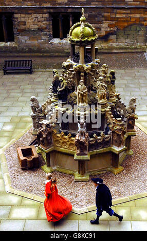 Junge Fremdenführer laufen am Linlithgow Palace in der Nähe von Edinburgh um den ältesten noch erhaltenen Brunnen Großbritanniens. Im Jahr 1537 von James V. in Auftrag gegeben, wurde es während eines fünfjährigen Projekts von Historic Scotland restauriert. Stockfoto