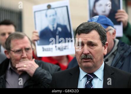 John Teggart (rechts), dessen Vater Danny 1971 während eines als Massaker von Ballymurphy bezeichneten Zwischenfalls von Soldaten erschossen wurde, sprach vor den Medien vor den Laganside Courts in Belfast, als eine Übersicht über die noch ausstehenden Inquests zu einer Reihe von umstrittenen Unruhen-Morden begann. Stockfoto