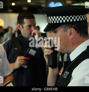Polizeibeamte sprechen bei einem Check-in am Terminal 4 des Londoner Flughafens Heathrow mit englischen Fans. Zwei Menschen wurden gestoppt, als die Polizei eine nationale Operation startete, um bekannte und mutmaßliche Störenfriede zu verhindern, die morgen gegen Dänemark in Kopenhagen in das England-Fußballfreundschaftssemble reisen. Stockfoto