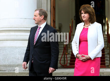 Taoiseach Enda Kenny, mit Tanaiste Joan Burton (rechts), vor Regierungsgebäuden, Dublin, nachdem er eine bevorstehende Parlamentswahl signalisiert und erklärt hat, dass das parlament erst im März 10 wieder sitzen wird. Stockfoto