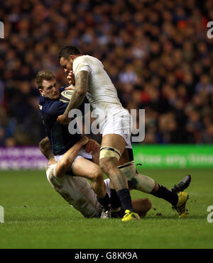 Der schottische Stuart Hogg wird während des RBS Six Nations-Spiels 2016 im BT Murrayfield Stadium, Edinburgh, von den Engländern Owen Farrell (links) und Courtney Lawes (rechts) in Angriff genommen. Stockfoto