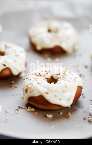 Selbstgemachte Donuts mit weißer Schokolade und Haselnuss topping Stockfoto