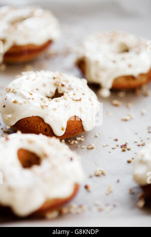 Selbstgemachte Donuts mit weißer Schokolade und Haselnuss topping Stockfoto