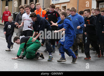 Boys tussle für den Lederball während der jährlichen "Fastern Eve Handba" Veranstaltung auf Jedburgh High Street in den Scottish Borders. Stockfoto