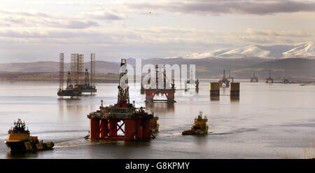 Die Ölplattform Stena Spey (links unten) wird mit Schleppern unter anderem im Cromarty Firth bei Invergordon in den Highlands of Scotland bewegt. Stockfoto