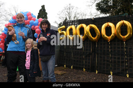 Jane Howorth (rechts), Gründerin des British Hen Welfare Trust, mit Julie Elliott (links) und ihrer Tochter Rosie (5), die die ehemalige kommerzielle Legehenne Dee wiederaufgenommen haben, als sie die 500.000. Henne wird, die vom British Hen Welfare Trust wiederaufgenommen wird. Stockfoto