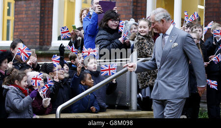 Nach seinem Besuch in der Burslem School of Art in Stoke-on-Trent jubeln und winken Kinder Fahnen für den Prinz von Wales, Patron und Gründer des Prince's Regeneration Trust. Stockfoto