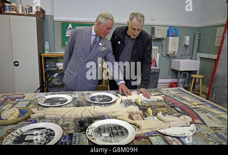 Der Prinz von Wales (links), Patron und Gründer des Prince's Regeneration Trust, und der Künstler Philip Hardaker betrachten Kunstwerke von Kindern während seines Besuchs an der Burslem School of Art in Stoke-on-Trent. Stockfoto