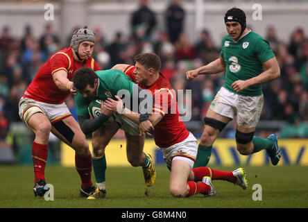 Der irische Jared Payne (Mitte) wird vom walisischen Nationalmannschaft Jonathan Davies und Rhys Priestland (rechts) während des RBS Six Nations-Spiels 2016 im Aviva Stadium, Dublin, angegangen. Stockfoto