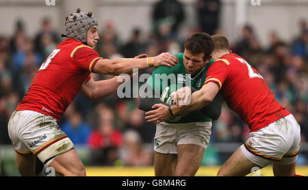 Der irische Jared Payne (Mitte) wird vom walisischen Nationalmannschaft Jonathan Davies und Rhys Priestland (rechts) während des RBS Six Nations-Spiels 2016 im Aviva Stadium, Dublin, angegangen. Stockfoto