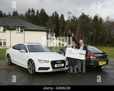 Der Gewinner der EuroMillions-Verlosung, Arthur Howard, und seine Frau Emma, feiern ihren 1-Millionen-Sieg neben Arthur's altem Taxi (rechts) und einem Audi, ähnlich dem, den er gekauft hat, während einer Fotowand im MacDonald Crutherland House in East Kilbride, Schottland. Stockfoto