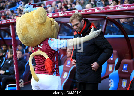 Liverpool-Manager Jurgen Klopp wird vor dem Spiel der Barclays Premier League im Villa Park, Birmingham, von dem Maskottchen der Aston Villa HerClues the Lion begrüßt. Stockfoto