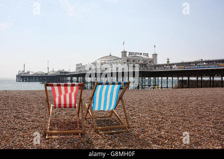 Liegestühle mit Blick auf Pier von Brighton Stockfoto