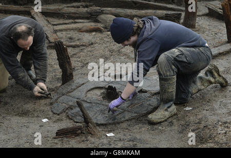 Archäologen arbeiten an der Gewinnung des frühesten vollständigen bronzezeitlichen Rades, das in Großbritannien gefunden wurde, datiert 1100-800 v. Chr., während der Ausgrabung der Must Farm in der Nähe von Peterborough in Cambridgeshire. Stockfoto