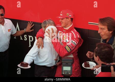 Formel-1-Chef Bernie Ecclestone bekommt Kuchen ins Gesicht Von Ferrari Michael Schumacher, als sie Ecclestones 100. Grand feiern Preis Stockfoto