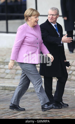 Die deutsche Bundeskanzlerin Angela Merkel (links) wird von Julian Evans, dem Protokolldirektor des Außenministeriums und des Commonwealth Office, begrüßt, als er im Queen Elizabeth II Conference Center in London ankommt, wo sich die Staats- und Regierungschefs der Welt zu Gesprächen über die syrische Flüchtlingskrise treffen. Stockfoto