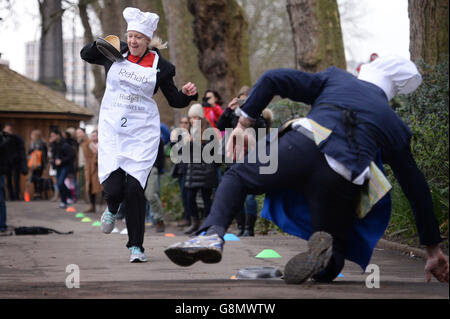 Die Abgeordnete Liz McInnes von Heywood und Middleton geht an Lord St John of Bletso vorbei, während sie am jährlichen Rehab Parliamentary Pancake Race teilnehmen, bei dem sich Abgeordnete, Lords und Mitglieder der Medien am Pancake Day gegenseitig Rennen, um Geld für die Wohltätigkeitsorganisation Rehab in Victoria Tower Gardens, London, zu sammeln. Stockfoto