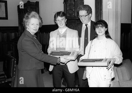 Die Premierministerin Margaret Thatcher in ihrem Privatzimmer im Londoner Unterhaus, mit Carmella Polcaro, 17, Robert Gray, 19, und der Abgeordnete William Powell von Corby (in specs). Die Teenager überreichten dem Premierminister den ein- und zweimillionsten Commodore Computers, der in Corby im Namen der Belegschaft der britischen Corby-Fabrik hergestellt werden soll. Margaret Thatcher wiederum wird die Computer an die Papst-Johannes-Schule in Corby spenden. Stockfoto