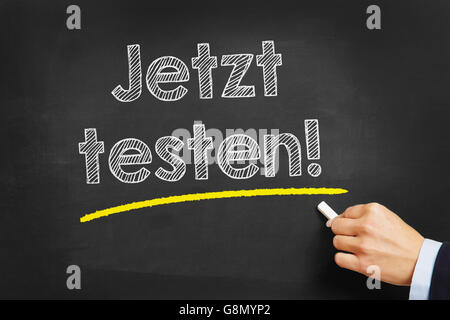 Hand mit Kreide schreiben in Deutsch "Jetzt Psychologieseite!" (jetzt testen) auf einer Kreidetafel Stockfoto