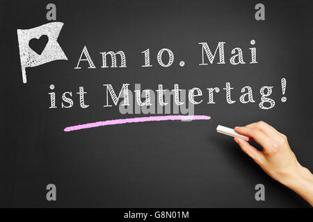 Handschrift in deutscher Sprache "bin 10. Mai ist Muttertag! " (Am 10. Mai ist Muttertag) auf Tafel Stockfoto
