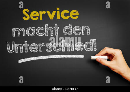 Hand, schreibt in Deutsch "Service Macht Den Unterschied!" (Service macht den Unterschied!) auf Tafel Stockfoto