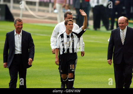 Newcastle United's Neuzugang Michael Owen (c) winkt der Menge zu, flankiert von seinem neuen Manager Graeme Souness (l) und dem Vorsitzenden Freddy Shepherd (r) Stockfoto