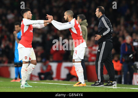 Arsenal gegen Barcelona - UEFA Champions League - 16. Runde - Erstes Teilstück - Emirates Stadium. Alex Oxlade-Chamberlain von Arsenal (links) ersetzt Teamkollegen Theo Walcott (rechts) Stockfoto