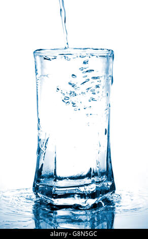 Wasserüberlauf in einem Glas, Isolated on White Background Stockfoto