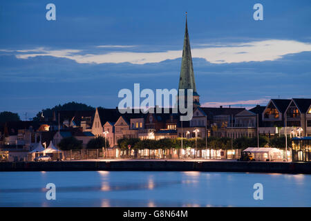 Ostpreußenkai, erste Reihe von Gebäuden mit St.-Lorenz-Kirche, Nacht, blaue Stunde, Küste Ostseebad Travemünde Stockfoto