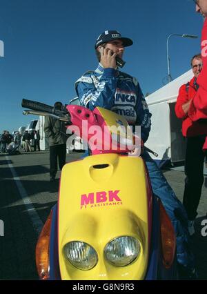 Formel 1 Motorsport - Großer Preis Von Luxemburg - Training. Damon Hill auf einem Roller im Nürburgring Paddock Stockfoto