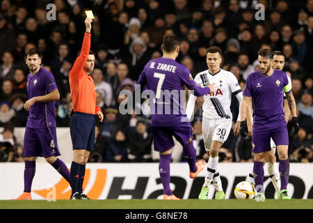 Fiorentina gegen Tottenham Hotspur - UEFA Europa League - Runde 32 - zweite Etappe - White Hart Lane. DELE Alli (20) von Tottenham Hotspur erhält eine gelbe Karte vom Schiedsrichter Ovidiu Hategan Stockfoto