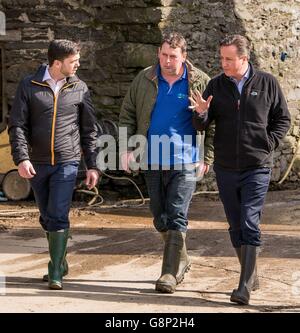 Premierminister David Cameron mit dem Farmbesitzer Richard Williams und dem walisischen Sekretär Stephen Crabb (links) während eines Besuchs auf der Tyfos Farm in Denbighshire, bevor er eine Rede auf der Konferenz der Walisischen Konservativen im Llangollen Pavillion, Llangollen, Nordwales, hielt. Stockfoto