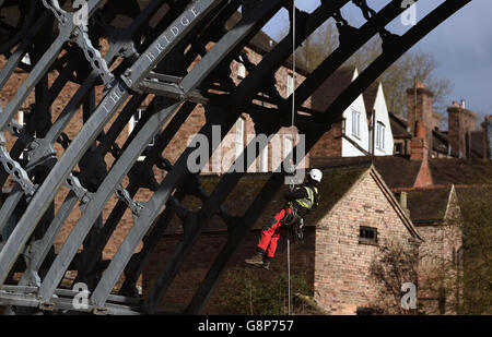 Ein Vermesser seils sich von der Eisernen Brücke über den Fluss Severn in Shropshire ab. Stockfoto