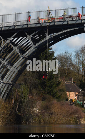 Ein Vermesser seils sich von der Eisernen Brücke über den Fluss Severn in Shropshire ab. Stockfoto