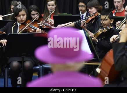 Königin Elizabeth II. Sieht das National Youth Orchestra of Great Britain bei ihrem Besuch in der Lister Community School in London spielen, um mehr darüber zu erfahren, wie der Queen's Trust die Arbeit verschiedener Wohltätigkeitsorganisationen in Schulen unterstützt. Stockfoto