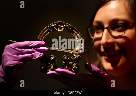 Kuratorin Adrienne Breignan betrachtet eine frühmittelalterliche vergoldete Silberbrosche aus AD700-800 aus Rogart in den schottischen Highlands als Teil der ersten großen britischen Ausstellung über die Kelten seit mehr als 40 Jahren im National Museum of Scotland in Edinbuurgh. Stockfoto