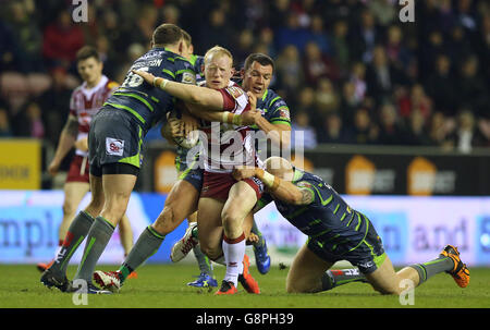 Liam Farrell von Wigan Warriors wird von Brad Singleton von Leeds Rhinos (links) Brett Ferres und Keith Galloway (rechts) während des ersten Utility Super League-Spiels im DW Stadium, Wigan, angegangen. Stockfoto