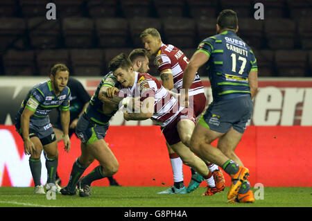 John Bateman von Wigan Warriors versucht sich beim ersten Spiel der Utility Super League im DW Stadium, Wigan, am Zak Hardaker von Leeds Rhinos vorbei. Stockfoto