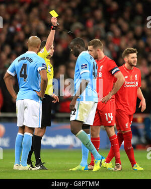 Liverpool gegen Manchester City - Capital One Cup - Finale - Wembley Stadium. Liverpools Adam Lallana (rechts) und die Yaya Toure (Mitte) von Manchester City erhalten gelbe Karten von Schiedsrichter Michael Oliver Stockfoto