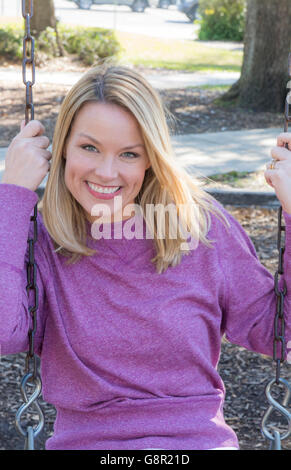 Junge Mutter Frau am Spielplatz Schaukel Portrait lächelnd mit Grübchen Modell veröffentlicht, Herr-6 Stockfoto
