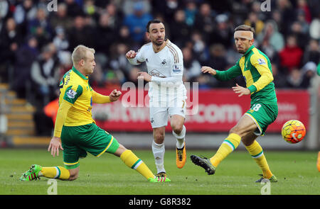 Leon Britton (Mitte) von Swansea City wird während des Spiels der Barclays Premier League im Liberty Stadium, Swansea, von Steven Naismith (links) und Gary O'Neil von Norwich City herausgefordert. Stockfoto