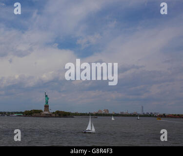 Kleine Boote gehen von der Freiheitsstatue in New York Stockfoto