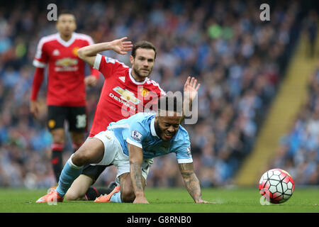 Raheem Sterling (rechts) von Manchester City wird beim Spiel der Barclays Premier League im Etihad Stadium in Manchester durch ein Tackle von Juan Mata von Manchester United verletzt. Stockfoto