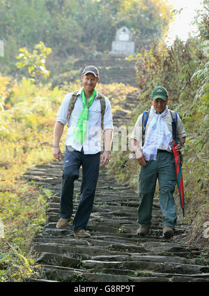 Prinz Harry treckt am vierten Tag seines Besuchs in Nepal in den Ausläufern des Himalaya aus dem Dorf Leorani. Stockfoto