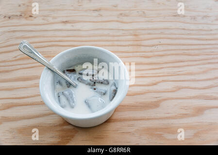 Köstlichen weißen Joghurt auf einen Topf mit Keksen auf hölzernen Hintergrund Stockfoto