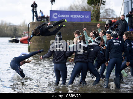 Cambridge Men's Blue Boat cox Ian Middleton (zweite links) und Oxford Women's Blue Boat cox Rosemary Ostfeld (links) werden in die Themse geworfen, während die beiden Crews ihre Siege bei den jeweiligen Bootsrennen auf der Themse, London feiern. Stockfoto