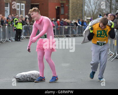 Ein Konkurrent lässt seine Kohle fallen, als er während der Kohletrahlenweltmeisterschaften in Gawthorpe, West Yorkshire, zur Ziellinie fährt. Stockfoto