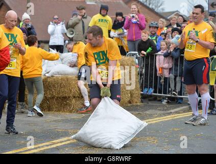 Ein Konkurrent schleppt seinen Kohlesack während der Kohlemeister-Weltmeisterschaft in Gawthorpe, West Yorkshire, bis zur Ziellinie. Stockfoto